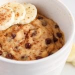 Close up on a vegan banana mug cake. The cake is also topped with sliced bananas.