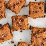 Overhead view on a vegan chickpea blondies squares from a plate that contains more of the square. This a close up picture so you can see the texture well.