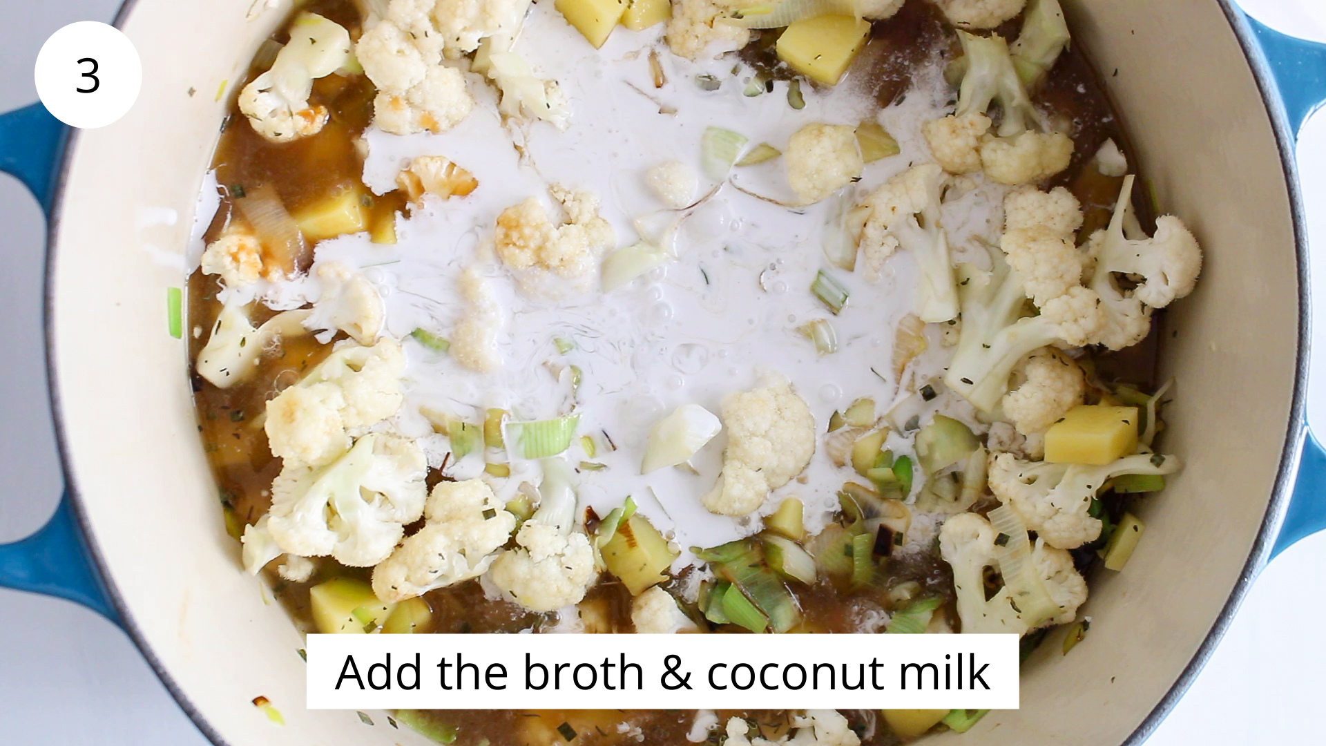 In process picture: overhead view on a large pot filled with veggies and broth.