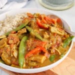 Front angle view on a homemade vegan coconut jackfruit curry filled with vegetables such as snap peas and red pepper.