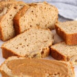 Close up on a wooden board filled with slices of banana bread.