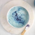 Overhead view on a large mug containing a vegan butterfly pea flower latte.
