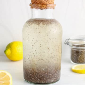 Close up on a large storing container filled with chia seed lemon water.