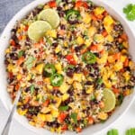 Overhead view on a large bowl of Brown rice and Quinoa Salad loaded with mango and vegetables.