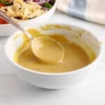 View on a spoon taking some of a balsamic tahini dressing.