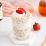 View on a small jar of vanilla overnight oats topped with yogurt and strawberries.