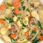 View on a bowl of vegan gnocchi soup with a spoon on the side.