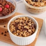 Close up on a few vegan baked oats for one with a focus on a chocolate chips flavored ramequin.