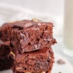 Close up on the top piece of a pile of vegan banana brownies to show the gooey texture.