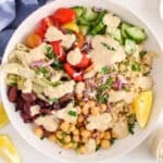 View on a bowl of Mediterranean chickpea quinoa bowl topped with a hummus sauce.