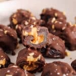Close up on the peanut butter stuffing in a date that's covered in chocolate.