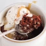 Close up on a spoon taking a bite of a vegan mug brownie.