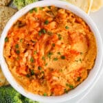Close up picture on a bowl of kimchi hummus with crackers on the side.