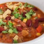 Close up on the garnishes on a vegan Mexican bean soup.