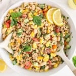 View on a large bowl of a creamy Tuscan white bean salad with slices of lemon.