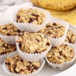 Front angle view on a pile of vegan 3-ingredients banana oatmeal muffins made with chocolate chips.