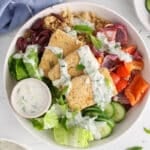 Overhead view on a vegan Greek marinated tofu bowl garnished with tzatziki.