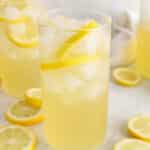 View on a tall glass of iced coconut water lemonade made with fresh lemons.