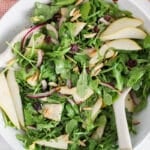 Overhead view on a large bowl filled with a rocket pear salad.
