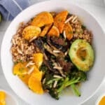 Overhead view on an ancient grain bowl including sweet potatoes, portobello mushrooms, broccoli and a miso orange sauce.