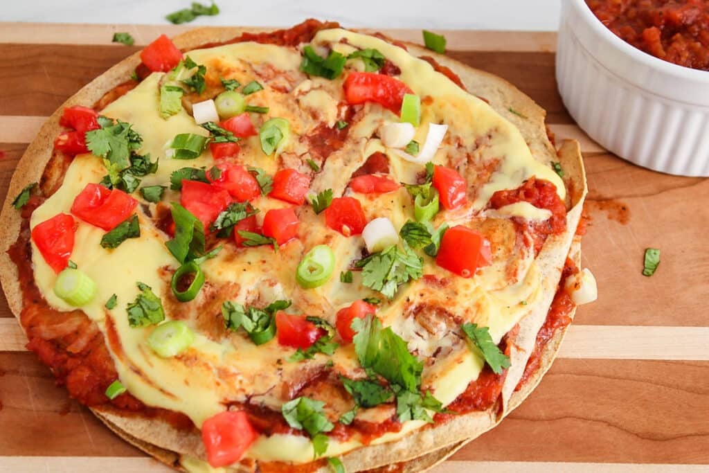 View on a tortilla vegan pizza Mexican style on a cutting board.