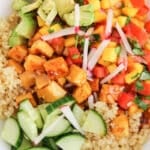 View on a tofu quinoa bowl garnished with cucumber and radishes.