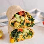 View on a kale wrap sliced in half on a plate.