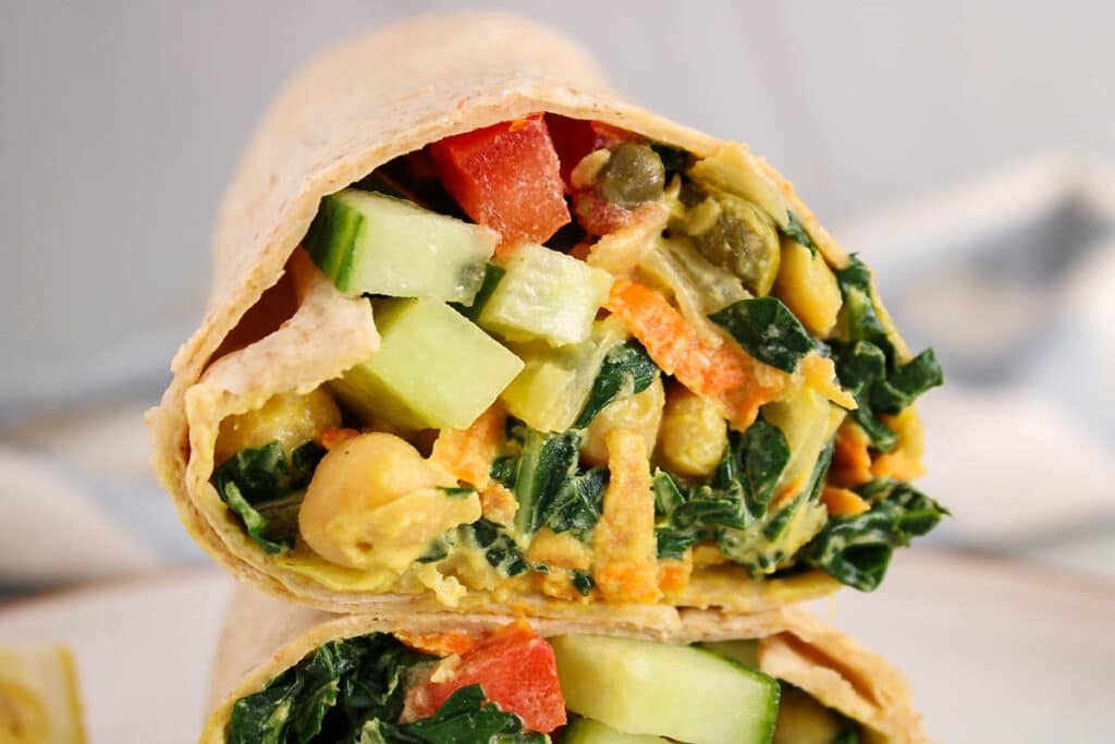 Close up on the creamy chickpea kale filling in a tortilla wrap.