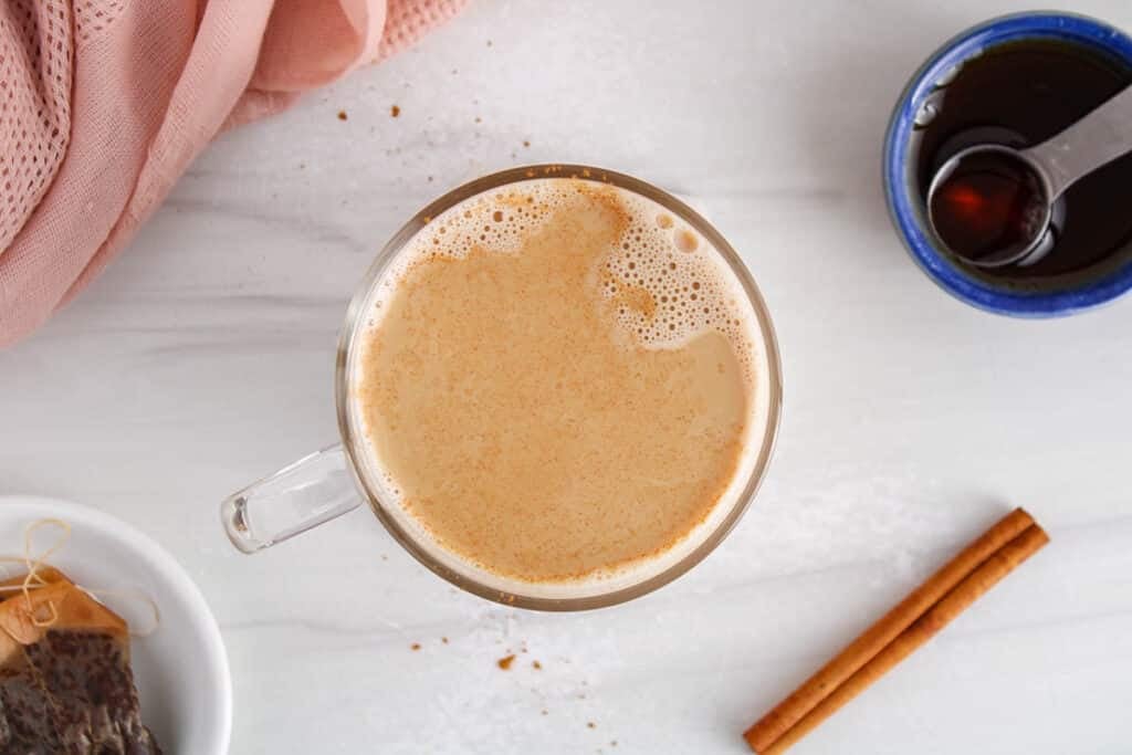Overhead view on a mug of cinnamon milk tea sprinkled with more cinnamon.