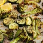 Front angle view on some roasted zucchini and broccoli tossed in herbs and lemon juice.