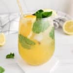 View on a mocktail made with apple cider vinegar and orange juice, and garnished with mint.