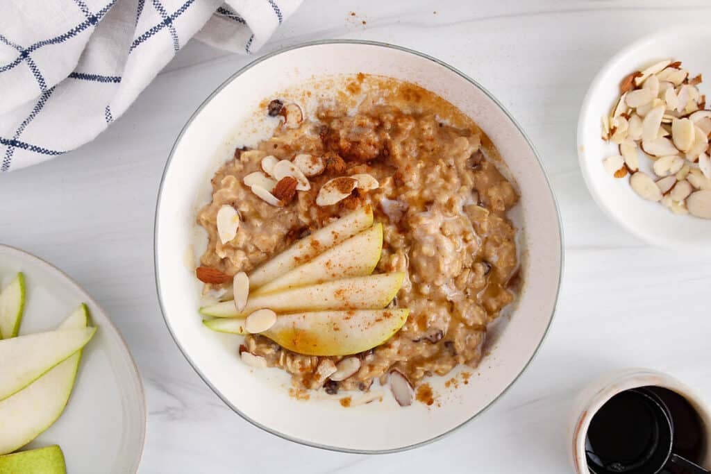 View on a bowl of creamy cinnamon spiced oatmeal with slices of pear.