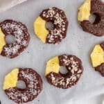 Overhead view on a few dark chocolate pineapple garnished with different ingredients.