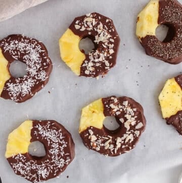Overhead view on a few dark chocolate pineapple garnished with different ingredients.