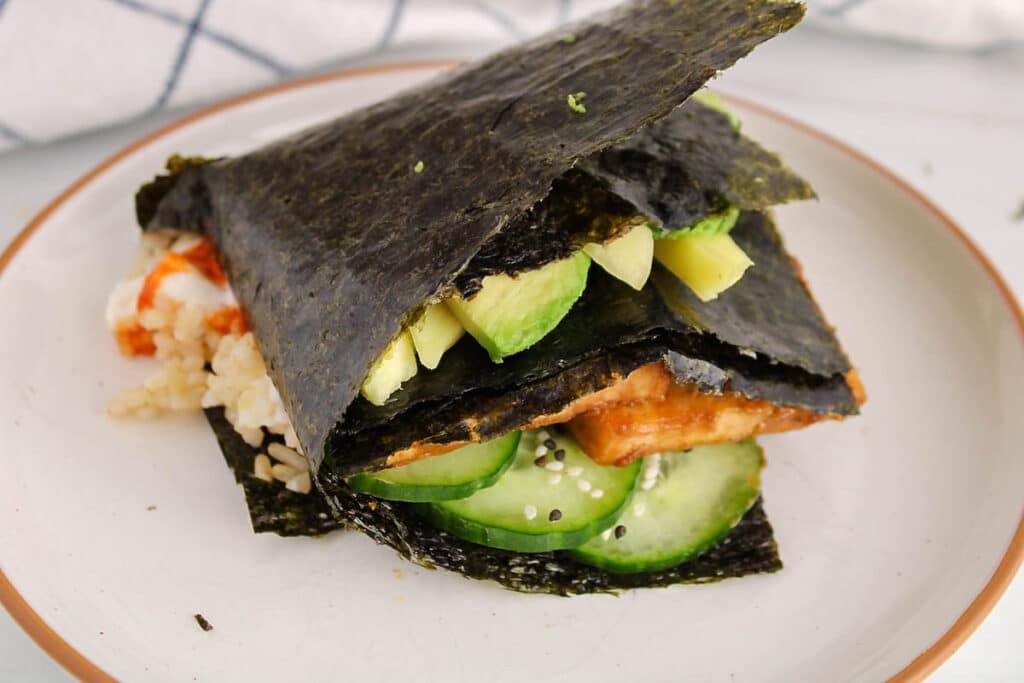 Overhead view on a closed up nori wrap on a plate.
