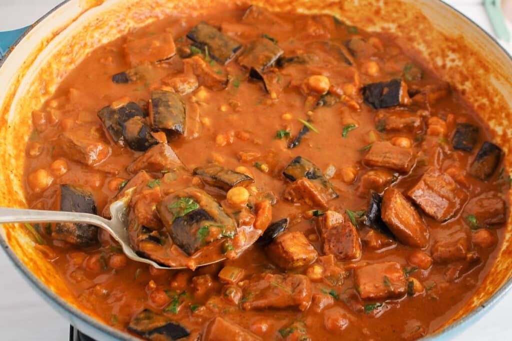 Close up in a large pan with a saucy eggplant tikka masala.