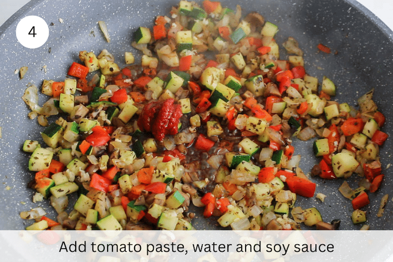 In process picture: add tomato pasta, soy sauce and water.