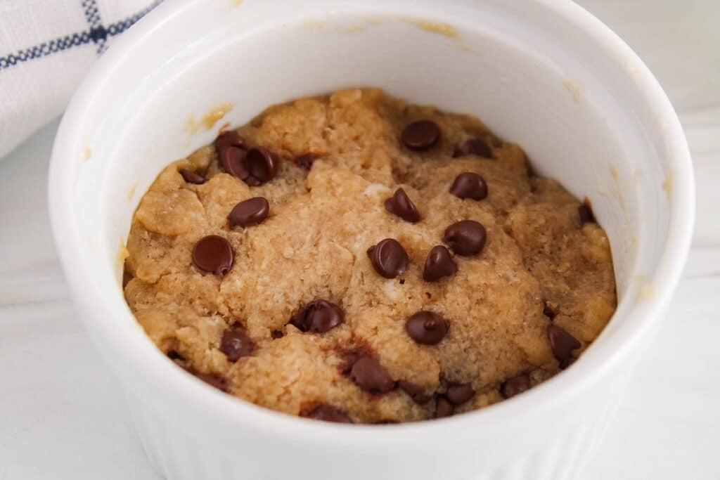 Close up on the top portion of a chocolate chips cookie in a mug.