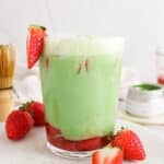 Showing a tall glass of iced strawberry matcha oat latte.