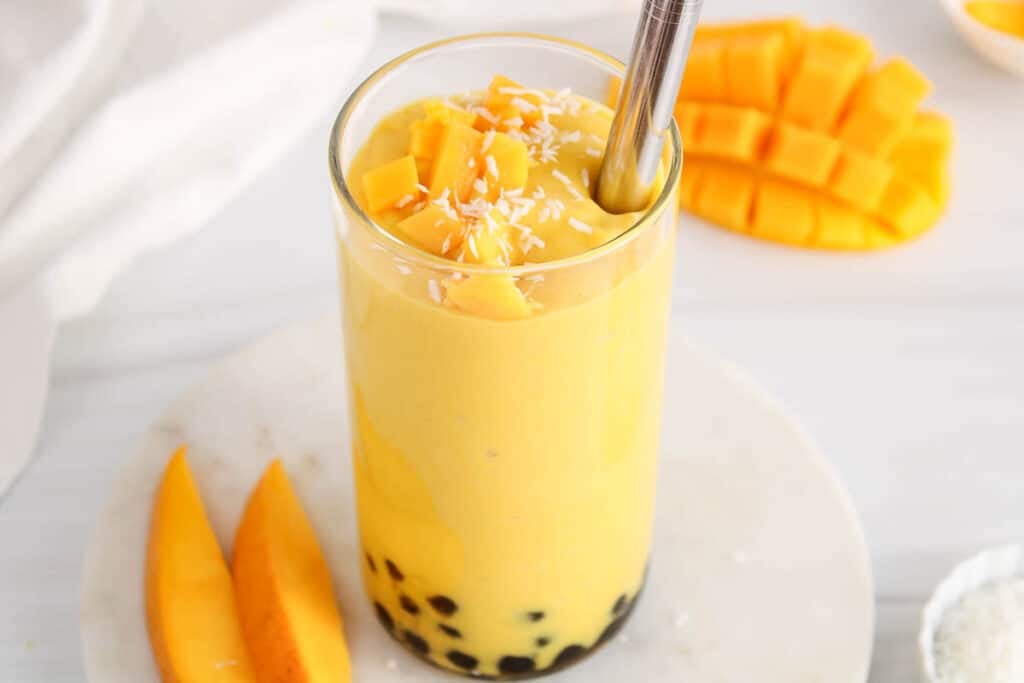 View on a tall glass of creamy tropical mango smoothie with boba.