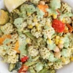 Overhead view on a bowl of dairy-free pesto pasta with vegetables.