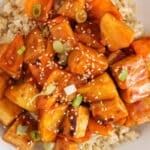 Showing large pieces of tofu and pineapple in a Asian sweet and sour sauce over rice.