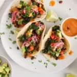 3 vegan kale tacos packed with black beans, pickled onion and avocado and garnished with a chipotle lime sauce.