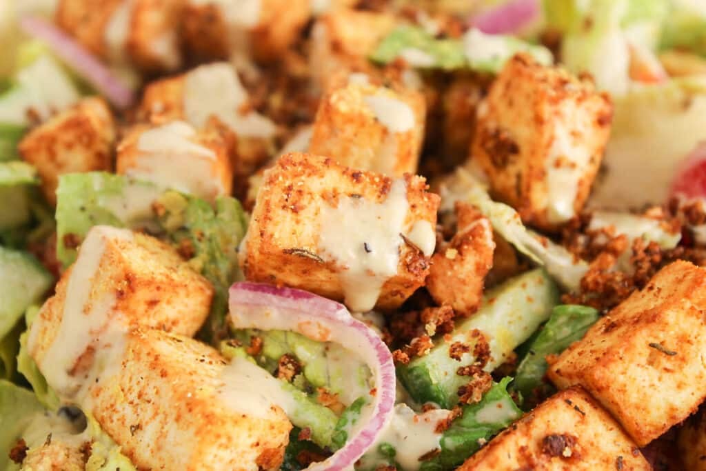 View on a cajun tofu bite topped with vegan Caesar dressing.