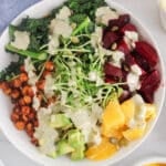 Vegan fall beet buddha bowl including brown rice, orange, spiced chickpeas and a tahini lemon sauce.