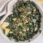 Creamy vegan kale white bean salad in a large serving bowl with serving spoons.