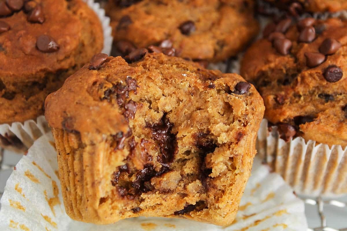View on a moist banana pumpkin muffins with a bite taken off.