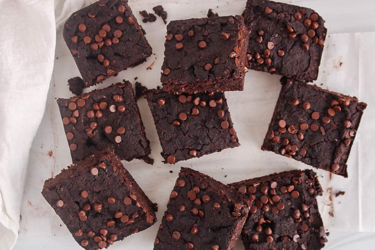 A few squares of vegan kidney bean brownies on parchment paper.