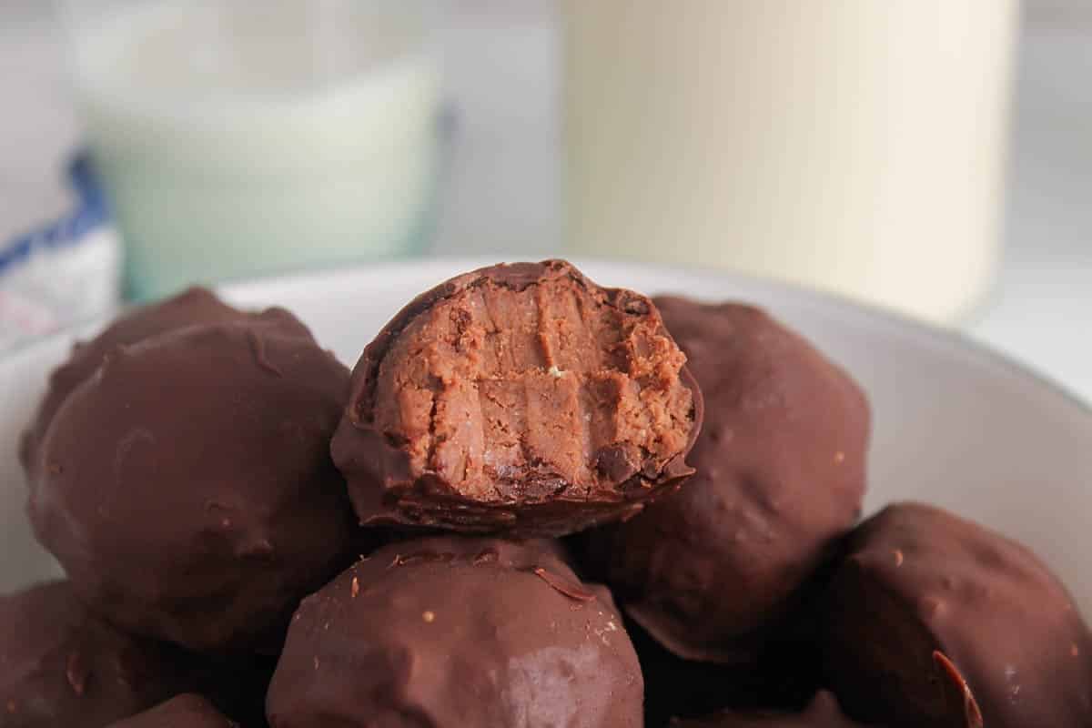 Chickpea truffle with a bite taken off showing the middles creamy interior.