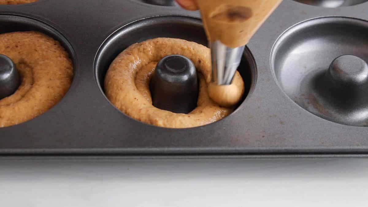 Plastic pipe transferring the donut batter into the donut mold.